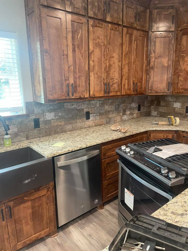 Natural stone tile kitchen backsplash and LVP floor installed in a Central Texas home