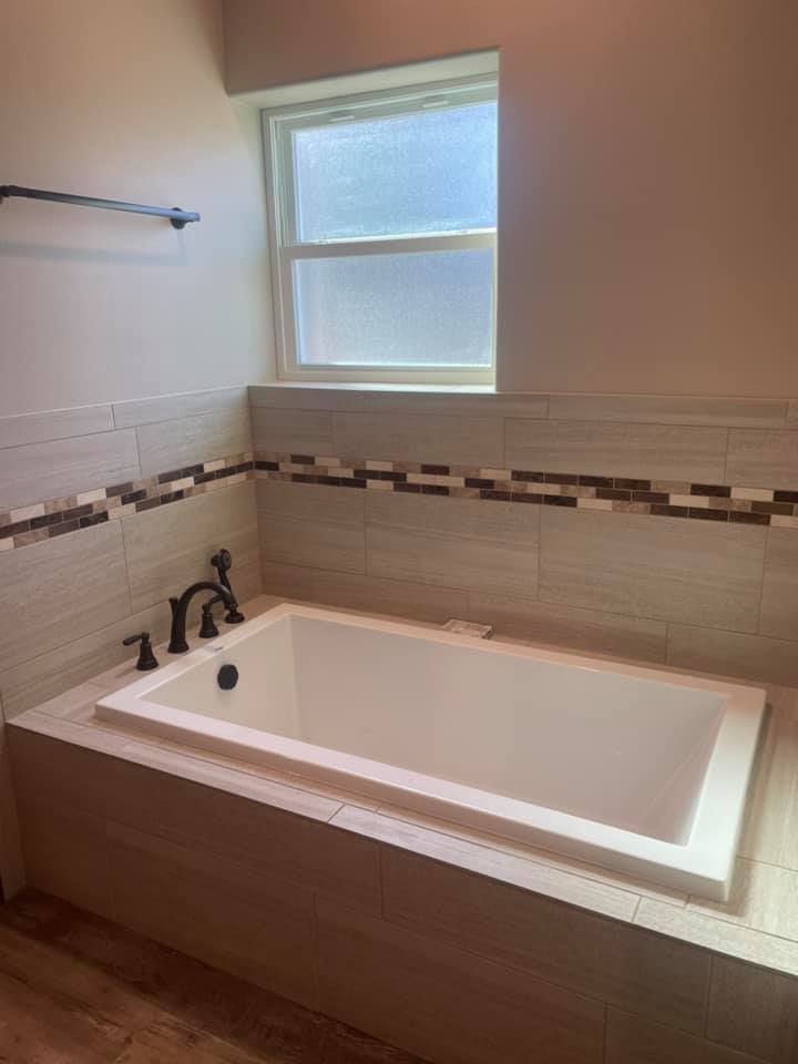 Tile tub surround with mosaic accent border installed by Heart of Texas Flooring